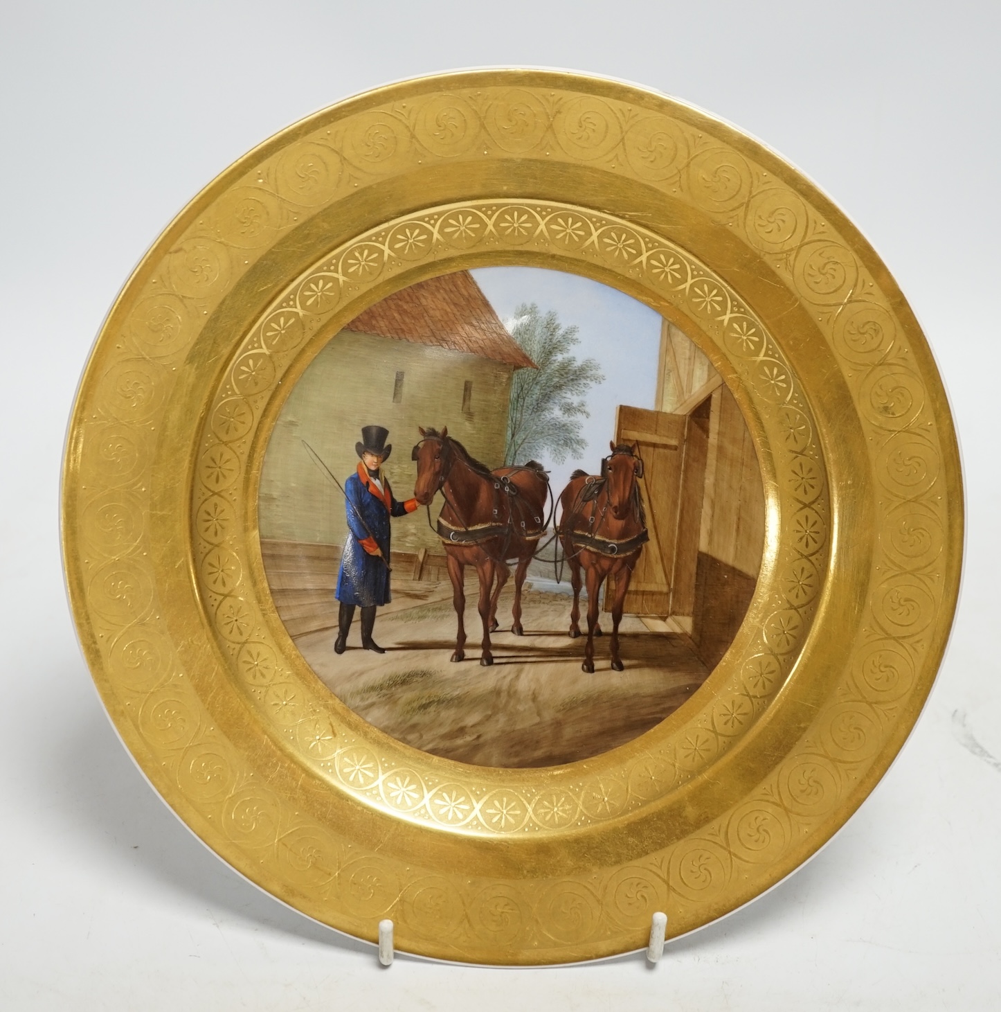 A Berlin porcelain dish painted with a groom with horses, first half of 19th century, 25cm diameter